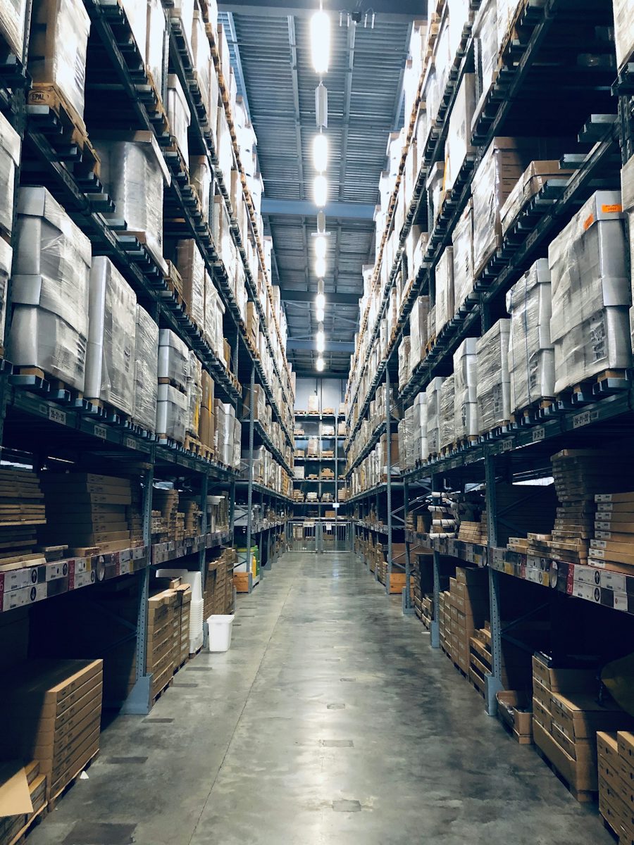 Warehousing and storage support &mdash; organised warehouse aisle with palletised cargo on high racking